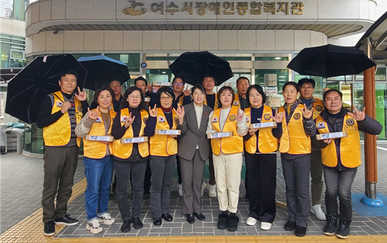 ▲ 진남라이온스클럽 회원들이 자원봉사 활동 후 기념품으로 받은 우산을 들고 사진촬영하고  있다.