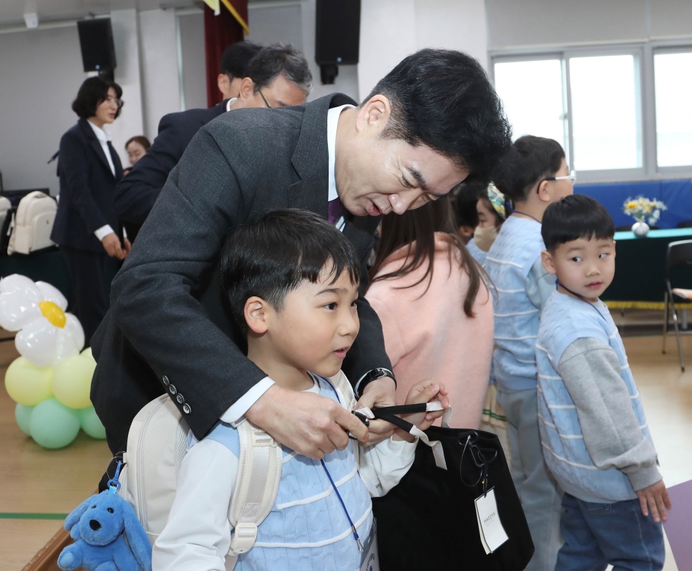 ▲김대중 전남교육감이 목포서산초등학교 입학생에게 책가방을 메어 주고 있다. ⓒ전라남도교육청