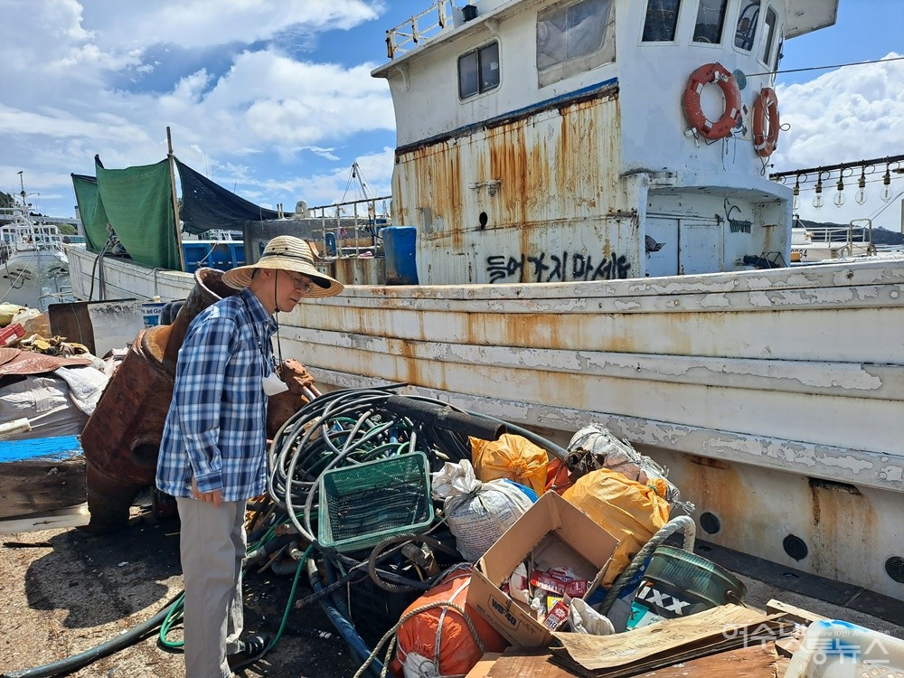 ▲정한수 여수환경운동연합 공동의장이 국동항에서 불법 수리 중인 선박에서 내다 버린 폐기물과 쓰레기를 살펴보고 있다. ⓒ조찬현  (자료사진)