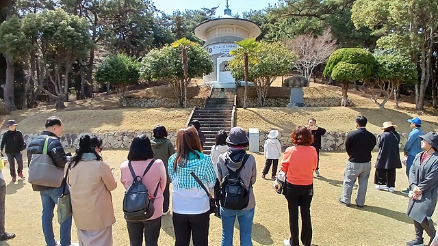 ▲소록도 한센인들의 유해가 모셔져 있는 만령당 앞에서 묵념을 한 후 조명래 학예사로부터 설명을 듣는 탐방객들 모습. 11,251위(2024.10.15기준)가 모셔져 있다. ⓒ오문수