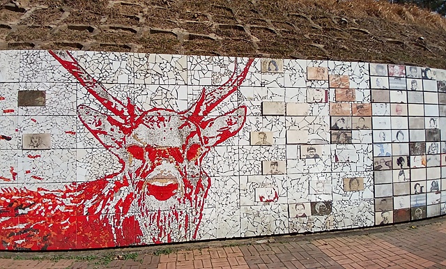 ▲국립소록도병원 뒤 옹벽에 그려진 사슴과 환자들의 얼굴이 희미하게 보인다 ⓒ오문수