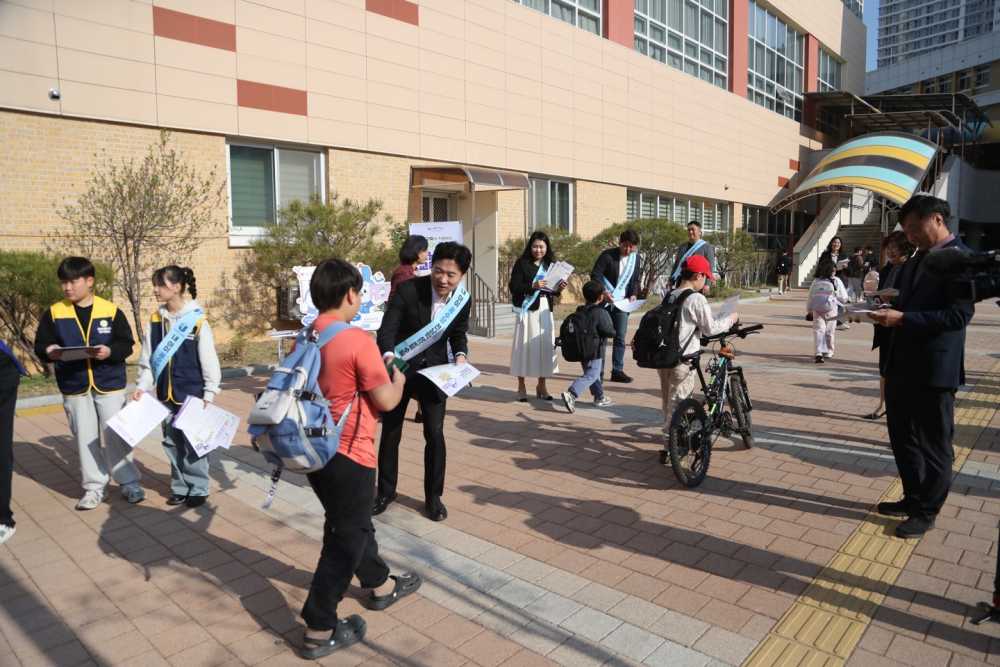 ▲전남교육청 관계자들이 등교하는 신대초등학교 학생들에게 전남학생교육수당 활용법 리플릿을 나눠주고 있다. ⓒ전라남도교육청