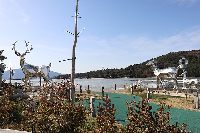 ▲녹동항 앞에 설치된 드론 공연장에 소록도를 상징하는 사슴동상이 서있다. 건너편에 보이는 섬이 소록도이다 ⓒ오문수
