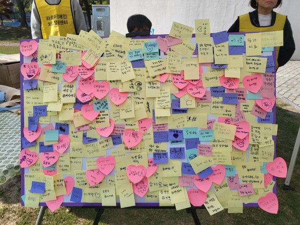 ▲  “모두가 일하는 여수시! 차별없이 일하는 장애인!”이라는 현수막 앞에서 진행자와 봉사자가 함께 단체사진을 찍고 있다.