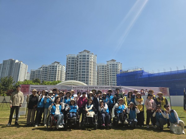 ▲  “모두가 일하는 여수시! 차별없이 일하는 장애인!”이라는 현수막 앞에서 진행자와 봉사자가 함께 단체사진을 찍고 있다.