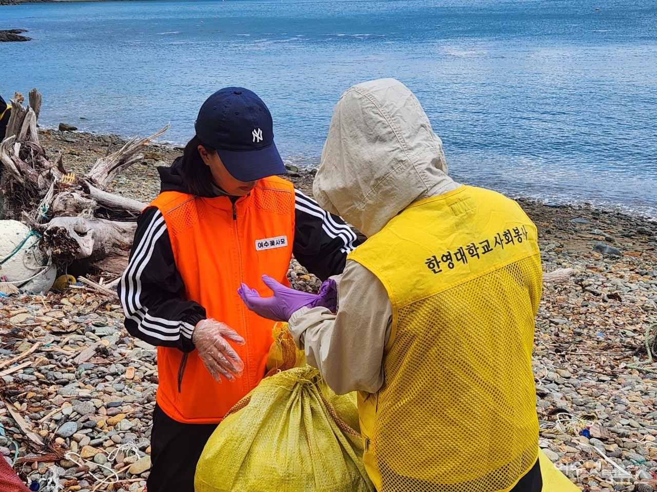 ▲ 제13회 바다 식목일을 맞아 남면 장지마을 해변에서 실시된 해양쓰레기 청결활에 여수꽃사모와 한영대학교 사회봉사팀 조끼가 보인다 ⓒ정종현