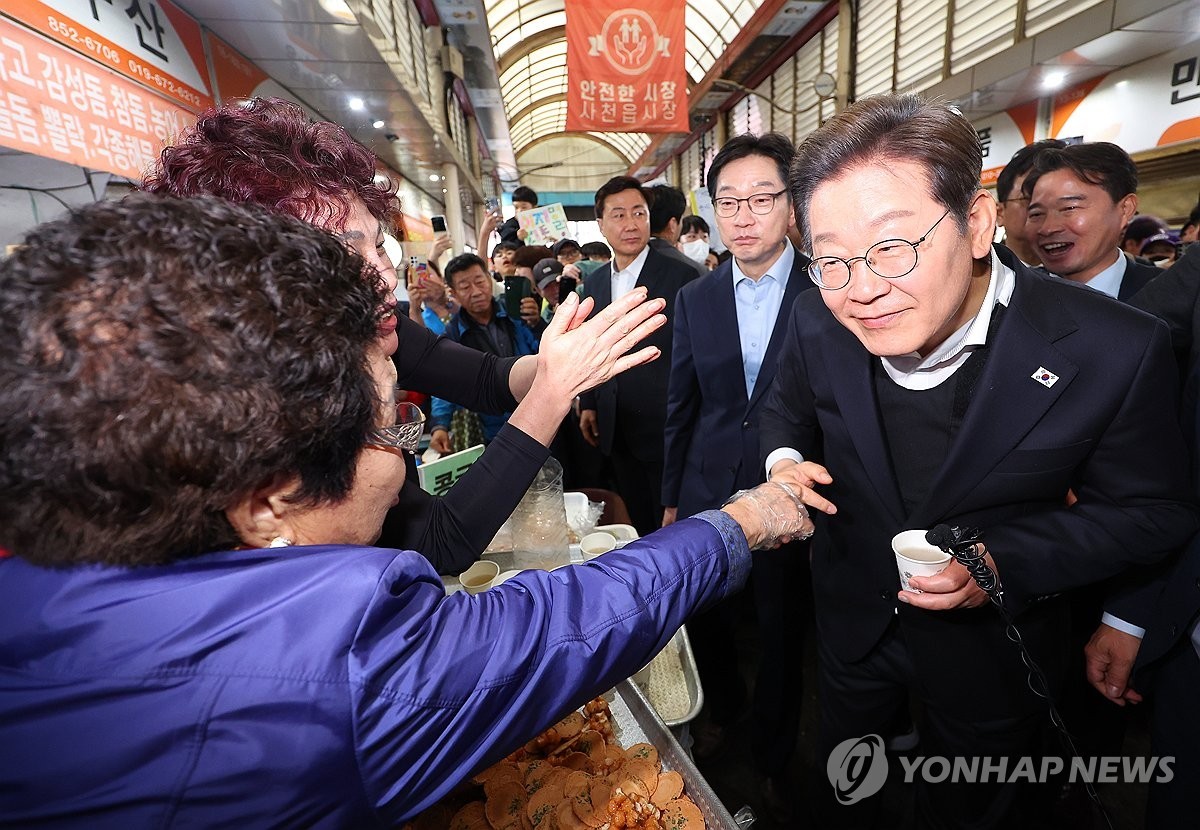 ▲ 사천읍시장 상인과 인사하는 이재명 후보