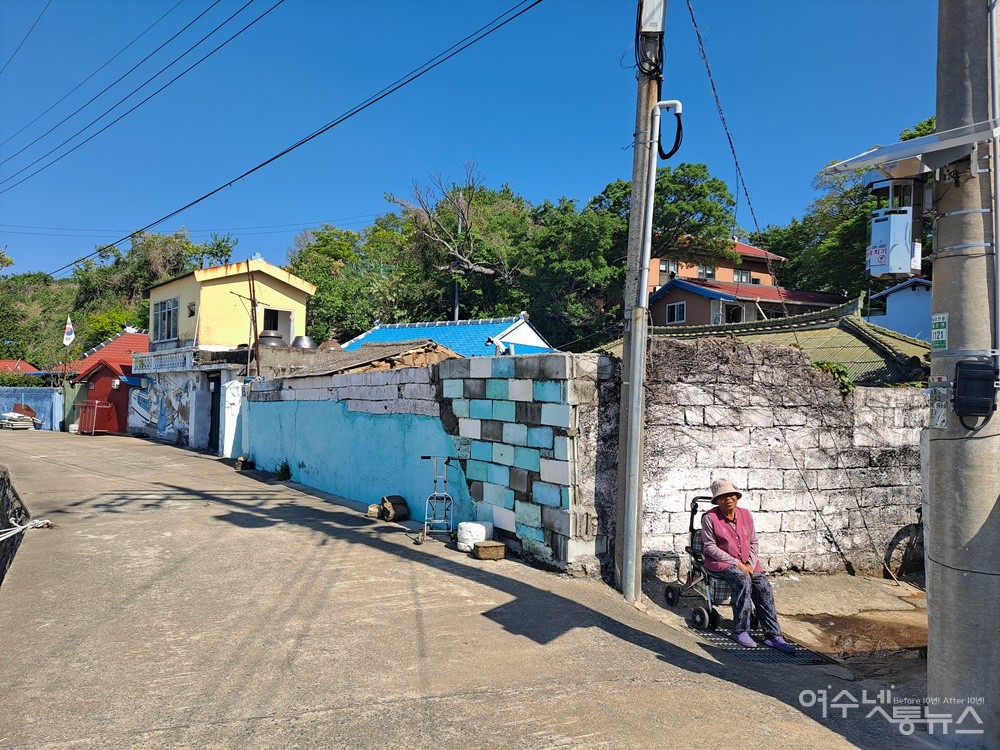 ▲ 어르신이 담장 곁에서 봄볕을 쬐고 있다. ⓒ조찬현