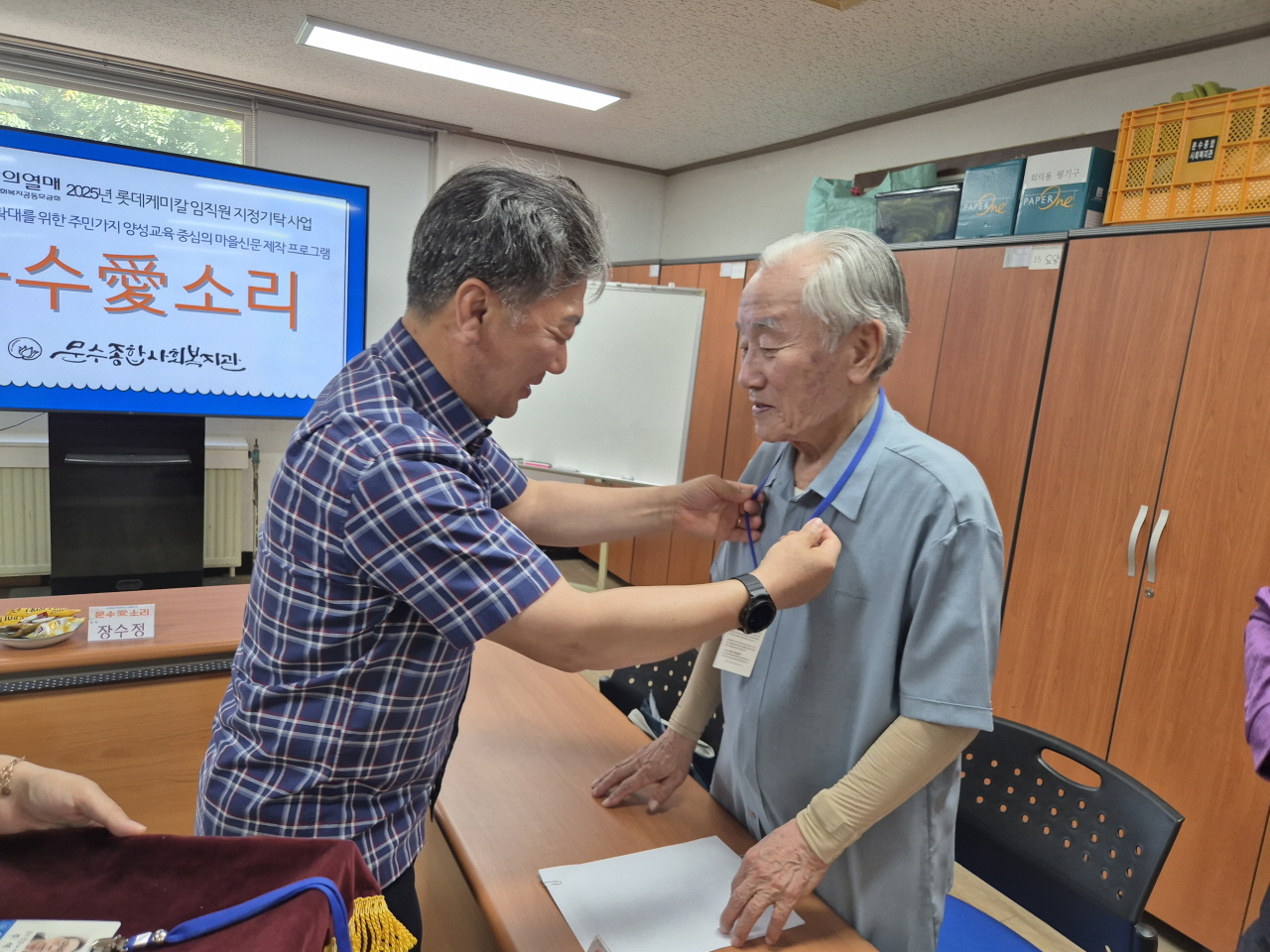 ▲임봉춘관장이 강동성 주민기자에게 기자증을 걸어주며 주민기자 위촉을 진행하고 있다. ⓒ문수종합사회복지관