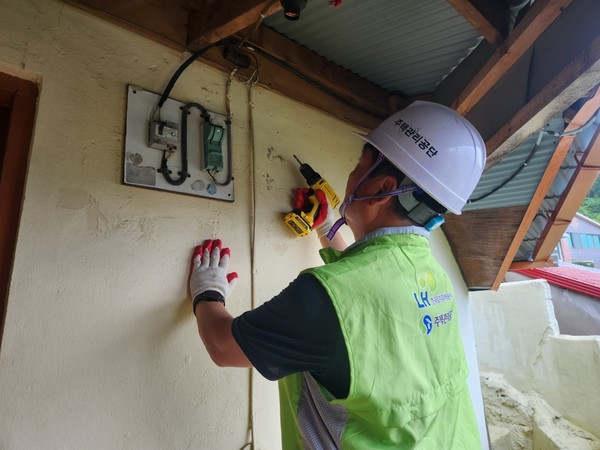 ▲ 외부에 노출된 차단기를 살피고 철거한는 주택관리공단 봉사단