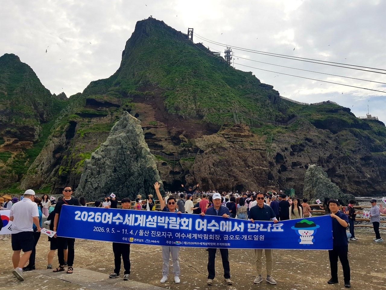 ▲ 여수시 방문단이 독도 현장에서 2026여수세계섬박람회 홍보 문구가 적힌 현수막을 들고 국제행사 홍보에 앞장서고 있다. ⓒ여수시