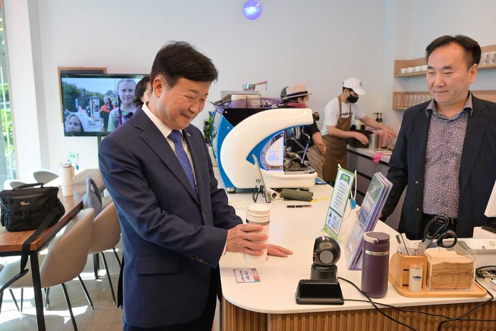 ▲정기명 여수시장이 관내 사회적경제기업 ‘모어레스커피’에서 탄소중립 실천포인트 앱 ‘반들이’ 이용법을 시연하고 있다. ⓒ여수시