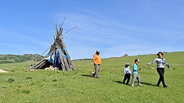 ▲몽골에서 가장 많이 볼 수있는 '어워' 모습. 어워 바로아래에는 샘물이 솟아 주민들이 신성시 여긴다고 한다. '어워'는 우리나라 시골의 산 고갯마루에 세워진 돌무덤을 연상하면 된다. 주민들의 뒤에 세워진 '어워'는 돌이 아닌 나무로 세워진 어워이다. '어워'의 재질별 분류로는 돌, 나무, 흙이 있다.  ⓒ박근세
