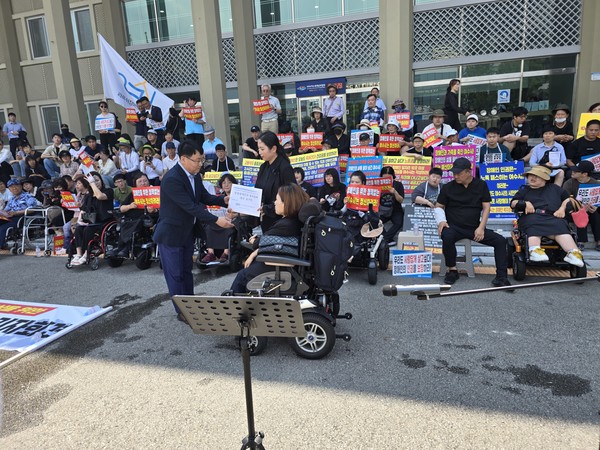 ▲  라르쉬장애인자립생활센터 이명주센터장이  복지교육국 김정오국장에게 장애인복지정책 요구안을 전달하고 있다.