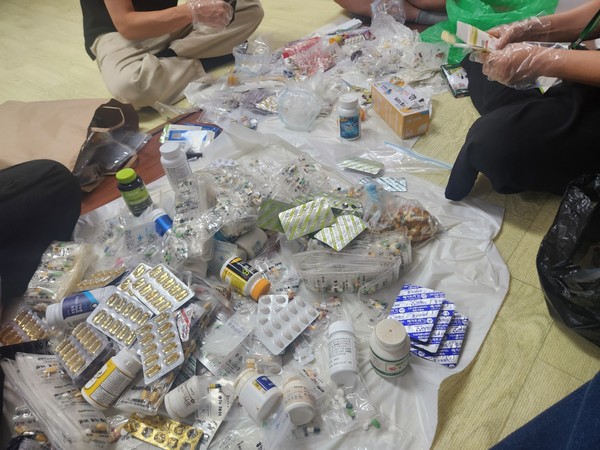 ▲ 수거된  약들을 알약과  연고등으로 분류작업중인 사회복지사 ⓒ문수종합사회복지관