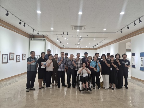 ▲ 서예교실 수강생들이 작품을 뒤로 기념촬영을 하고 있다.