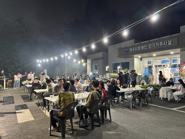 ▲푸짐한 음식과 음악공연을 함께 감상하고 있는 입소인 가족, 자원봉사자, 후원자들 