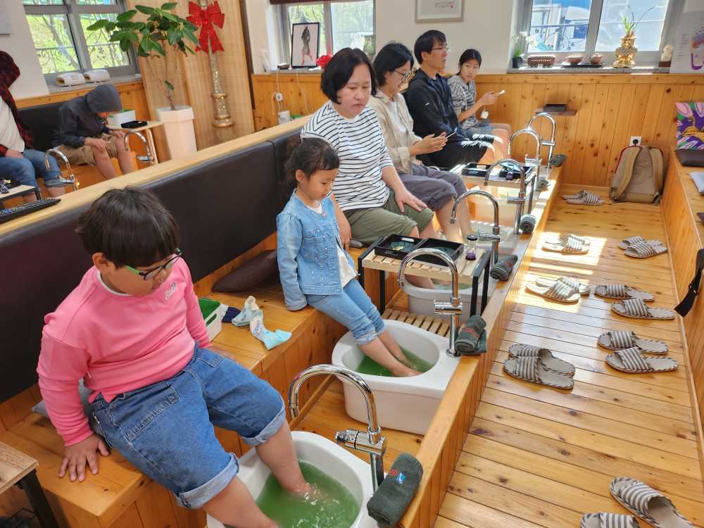 ▲캠프에 참여한 학생과 가족들이 24일 보성에서 녹차 족욕을 즐기고 있다. ⓒ전라남도교육청