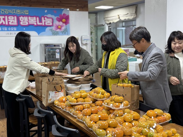 ▲ 삼계탕, 단감, 귤 등 건강식품꾸러미를 포장하는 모습 ⓒ쌍봉종합사회복지관