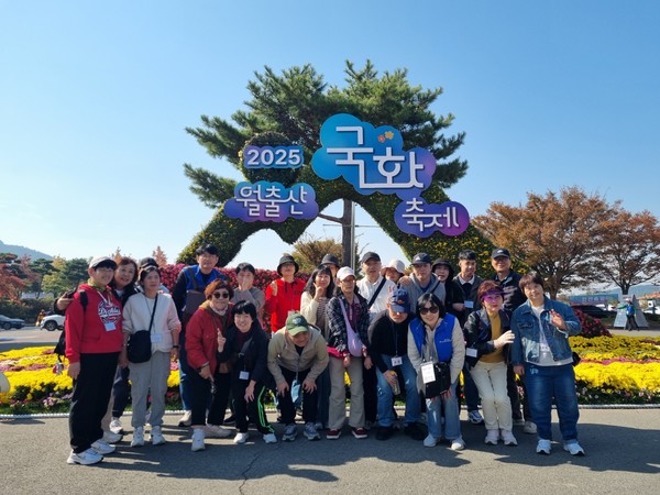 ▲국화조형물 앞에서 추억을 남기고 있는 참여자들 모습 ⓒ여수시장애인종합복지관