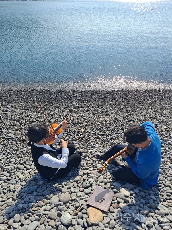 ▲ 여수시 화정면 개도리 모전마을 몽돌 해변에서 바이올린 이은주, 클래식기타 박두규 씨가 합주를 하고 있다. ⓒ조찬현
