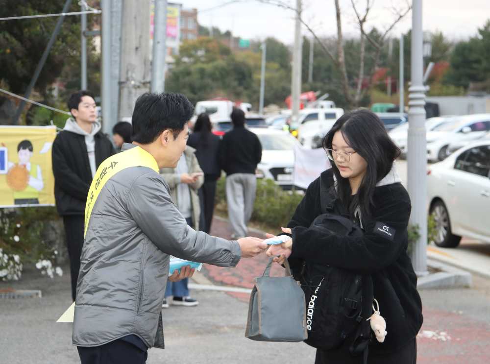 ▲김대중 전남교육감이 13일 오전 75지구 제7시험장인 순천복성고등학교 교문에서 수험생들에게 핫팩을 전하며 격려하고 있다. ⓒ전라남도교육청