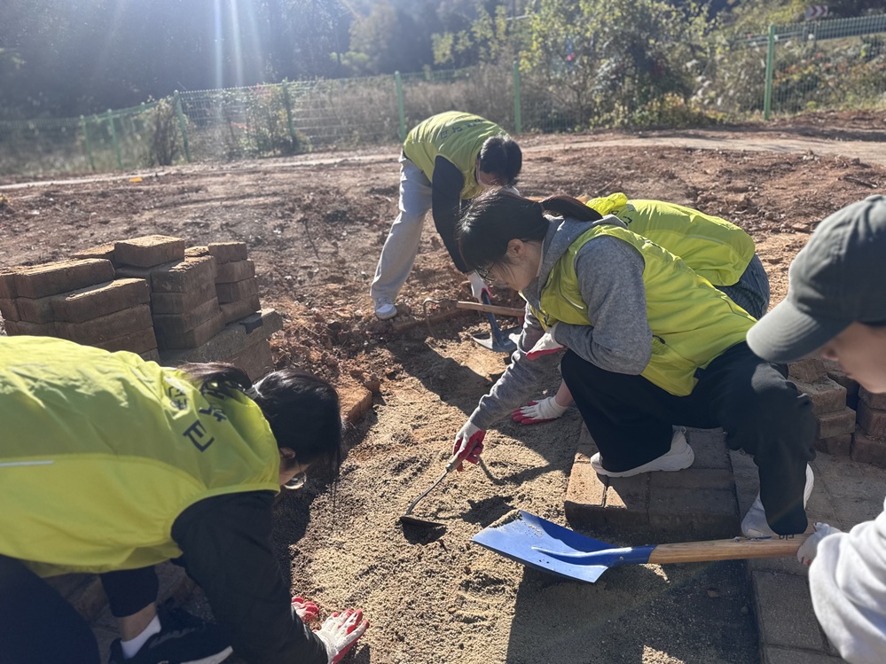 ▲ 주차장 보도블럭을 정비하고 있는 '고마운 물' 회원들 ⓒ 한영대학교