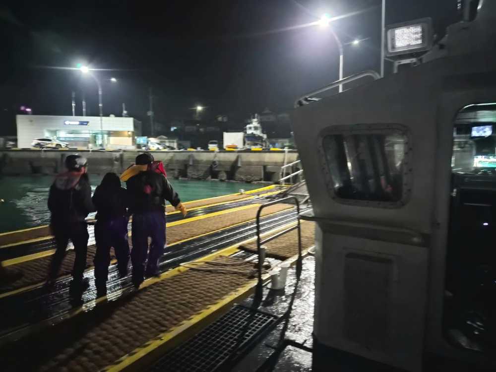 ▲ 여수해경 경찰관이 구조된 선원을 부축해 육상으로 이송하고 있다. ⓒ여수해양경찰서