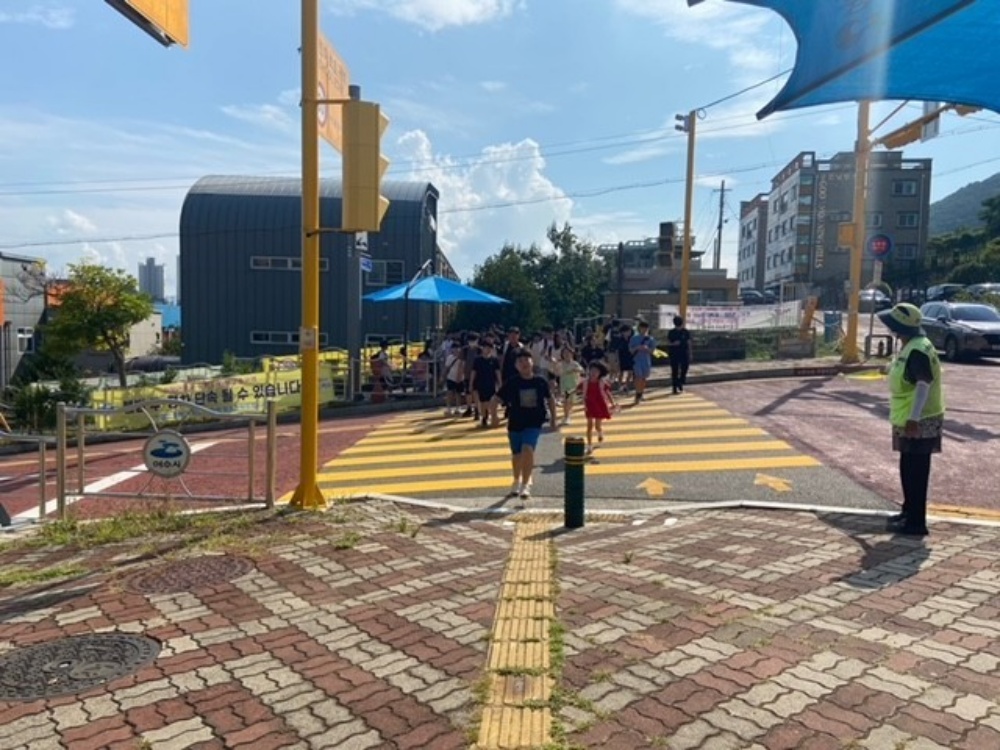 ▲등하굣길 안전지킴이의 교통안내 지도에 따라 학생들이 안전하게 하교하고 있다. ⓒ여수시